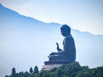 Giant Buddha Po Lin Monastery viewed from far distance with mountain ridgeline in distance, Lantau Island, Hong Kong