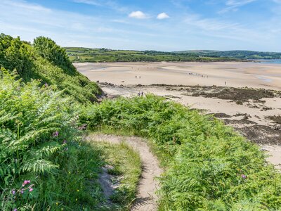 Coastal pathway near Traeth Lligwy beach and sea on sunny day in Anglesey