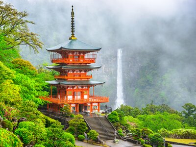 Vibrant orange Nachi Taisha Shrine Pagoda with waterfall in background, Japan