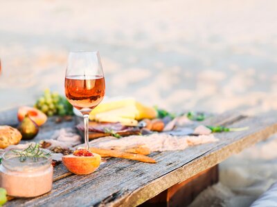 Glass of rose wine on rustic wooden table with food