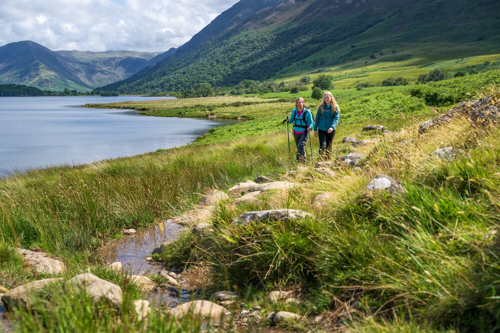 Two women walking through Buttermere Valley in the Lake District