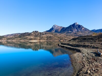 Body of clear water with clear blue sky and sharp mountain peaks in background at Grazalema national park (Parque Natural Sierra de Grazalema), Andalucia, Spain