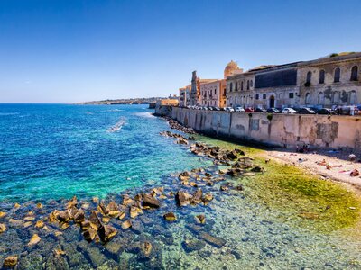 Turquoise and green tinted water seafront in Ortygia, Syracuse, Italy