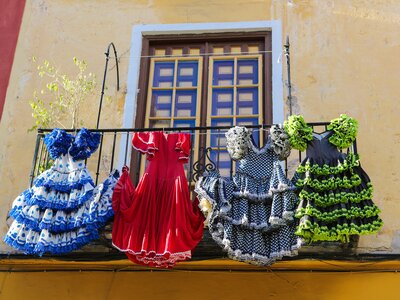 Colourful patterned flamenco dresses hanging outside on balcony, Spain