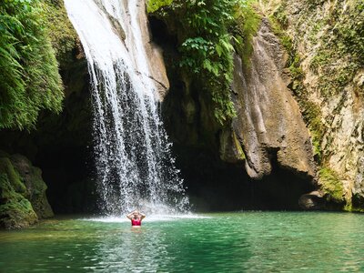 Woman emerging from the water beneath a waterfall, Cuba