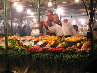 Two market traders haggling over street food in Jemaa el fna souk, Marrakech, Morocco