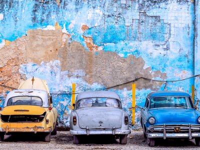 Old cars against a striking, faded wall, Havana, Cuba