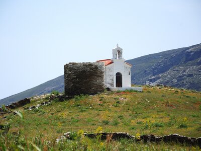Church atop grassy hill in Korthi, Andros island Greece