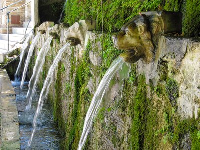 Stone fountains carved in the shape of lion heads with water exiting mouths in the old village of Menites, in Andros island, Greece