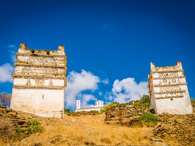 Dovecote towers in Andros on hill on sunny day, Cyclades, Greece, Europe