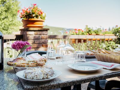 Outdoor table set for brunch, slices of spiced cheese focaccia and wine, Barolo Italy