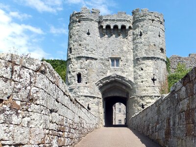 Low angle view of Carisbrooke Castle with stone walls leading towards archway entrance, Isle of Wight, England