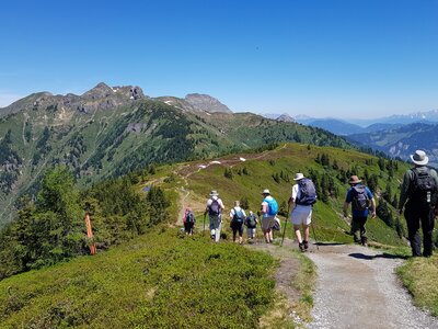 Ramble Worldwide walking holiday group descending slope atop mountain ridge in Austrian Alps