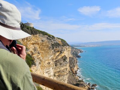Ramble Worldwide rambler taking picture of coastal cliff edge and sea near Mirador Torre del Tajo - Medio Ambiente, Spain
