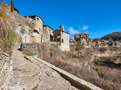 Stone pathway leading up to medieval Catalonian village of Rupit on sunny blue sky day, Barcelona province, Spain