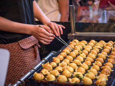 Close up of Japanese street food octopus balls known as Takoyaki being prepared at a food stall in Dotonbori in Osaka, Japan