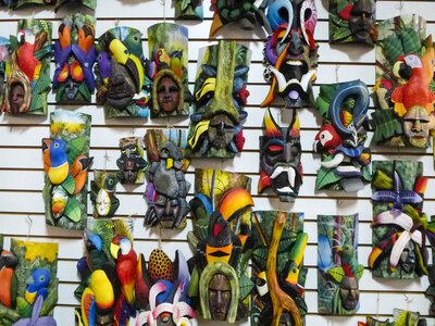 Many hand-carved and painted colourful wooden artwork hanging on wall, Costa Rica
