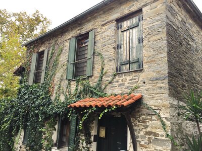 Traditional stone house façade with wooden shutters on windows, Halkidiki, Olympiada, Greece