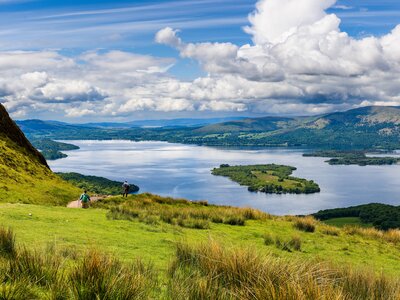 Hikers descending Conic Hill towards Loch Lomond with mountain scenery, Scotland