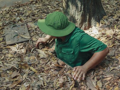 Local demonstrating an entrance to the Cu Chi Tunnels used by the Viet Cong, near Ho Chi Minh City, Vietnam