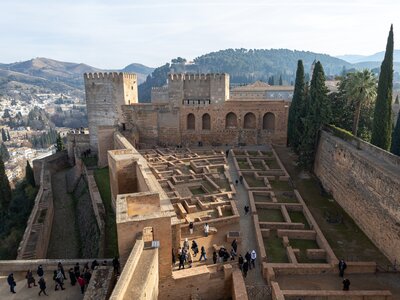 High angle looking down of tourists walking into outdoor garden area of Alhambra palace, Granada, Spain