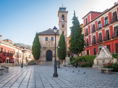 Streets of Albaicin district in Granada with colourful red, yellow, and beige buildings, Spain