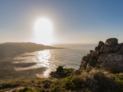 Low sun shining across beach water of Trece from Monte Branco, Camarinas, La Coruna, Spain