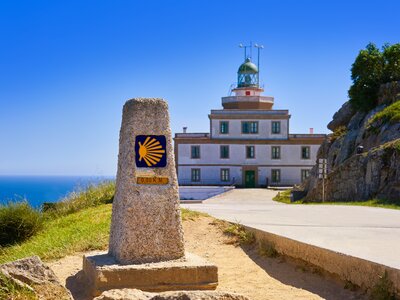 End of Saint James Way sign and lighthouse of Finisterre in Galicia, Spain