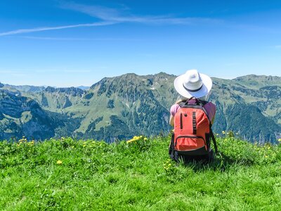 Woman sat on grassy mountain admiring Austrian mountain view, Austria