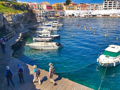 Group of people walking along dock at marina, Menorca