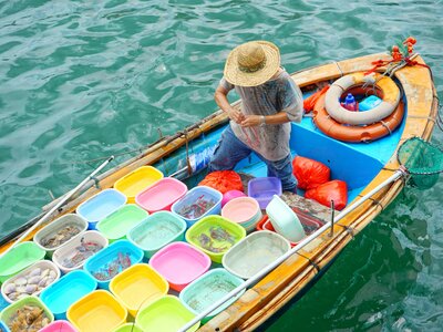 Fisherman selling seafood from boat at the pier in Sai Kung, Hong Kong