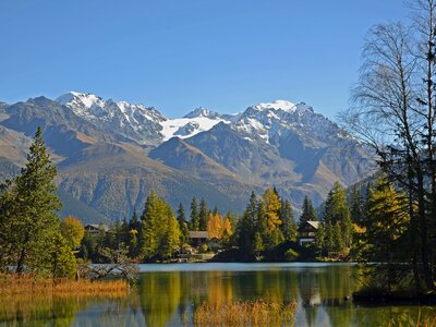 Champex-Lac mountain village by scenic lake with snow-capped mountains in far distance, Chamonix, France, Europe