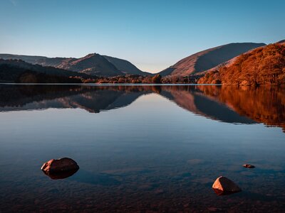 Grasmere Lake reflections at sunset in the autumn season with clear blue sky, Lake District, Cumbria