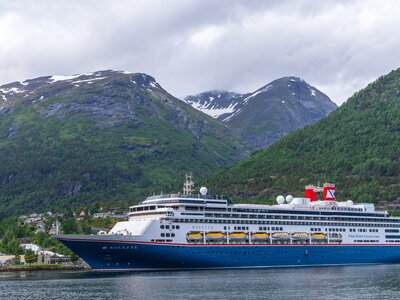 Fred Olsen cruise ship Bolette docked up at port in Norway with mountains in background