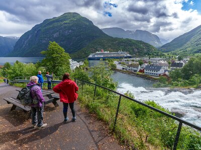 People on Ramble Worldwide walking holiday in Norway enjoying view of Alesund port town and fjords next to cascading river, Norway, Europe