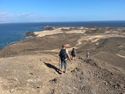 Descending to moon-like landscape with blue sea in distance, Fuerteventura