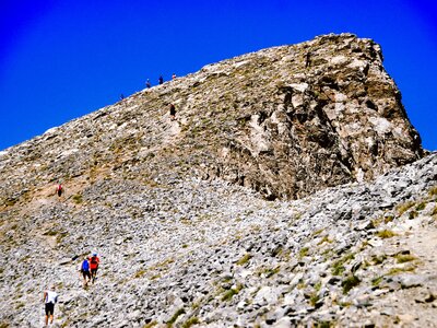 Hikers on stone path trekking up Mount Olympus towards Skolio summit, Greece