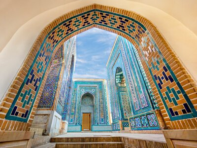 Shahi Zinda with its finely decorated mausoleums through an arch in Samarkand, Uzbekistan