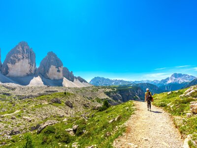 Tourist walking on a mountain path near tre cime di lavaredo in the dolomites enjoying the summer landscape, Italy