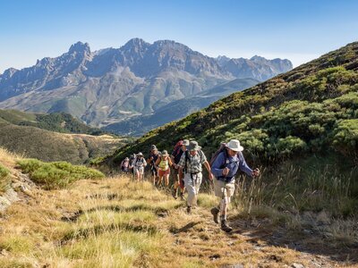 Ramble Worldwide walking group ascending grassy hill in Picos De Europa, Spain